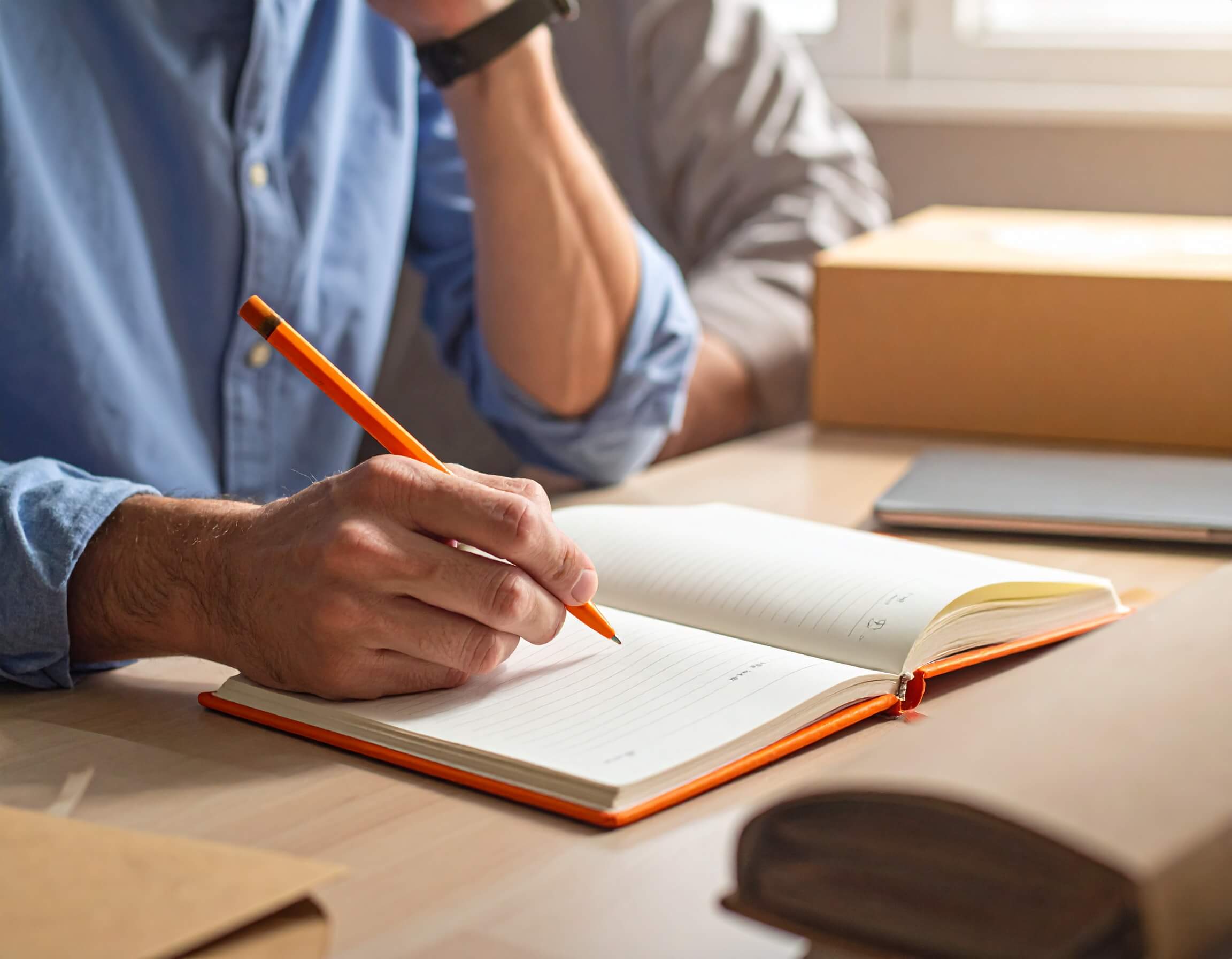 Man writing in a notbook sitting in a digital strategy agency office