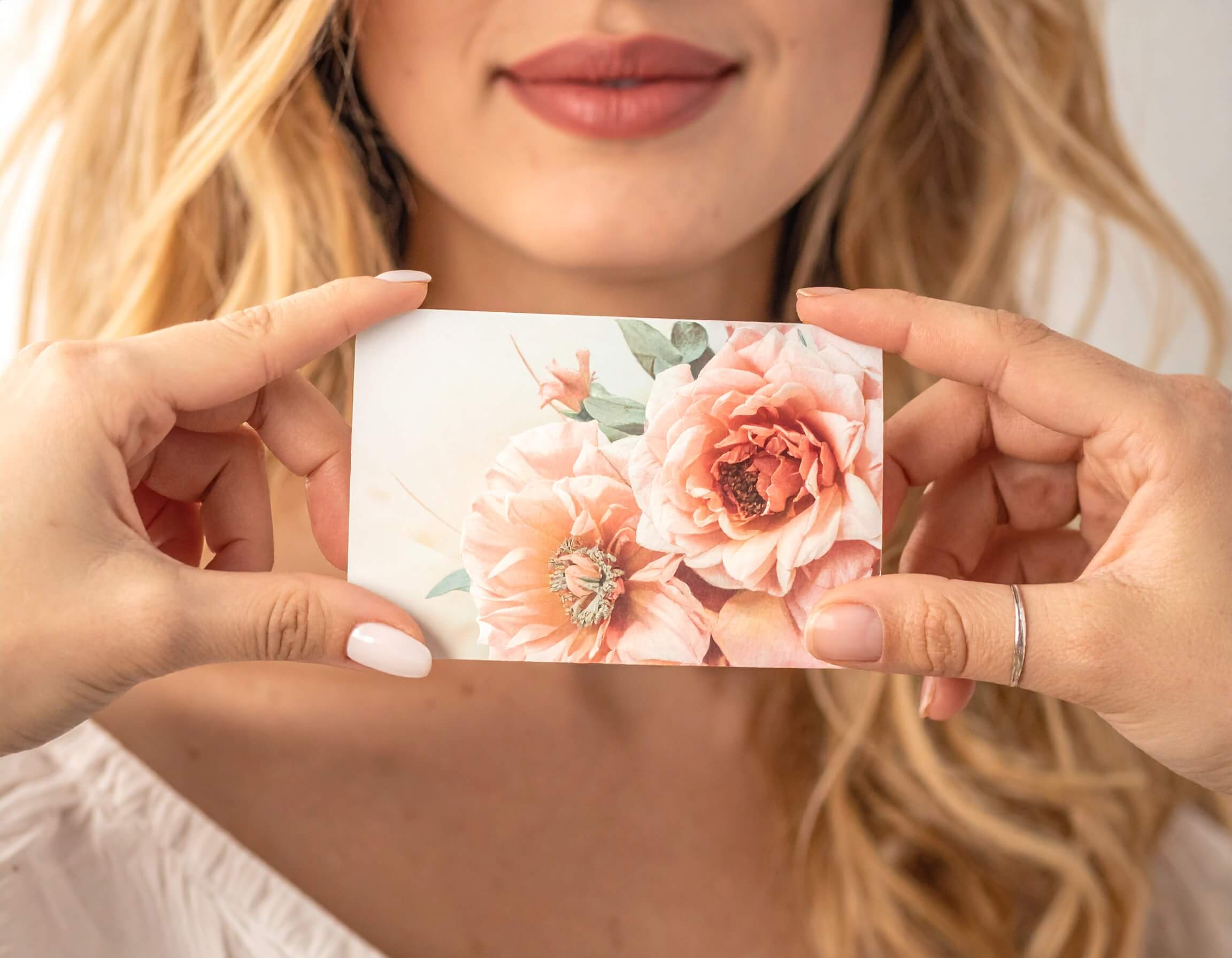 A woman holding a gift card representing a referral marketing consultancy