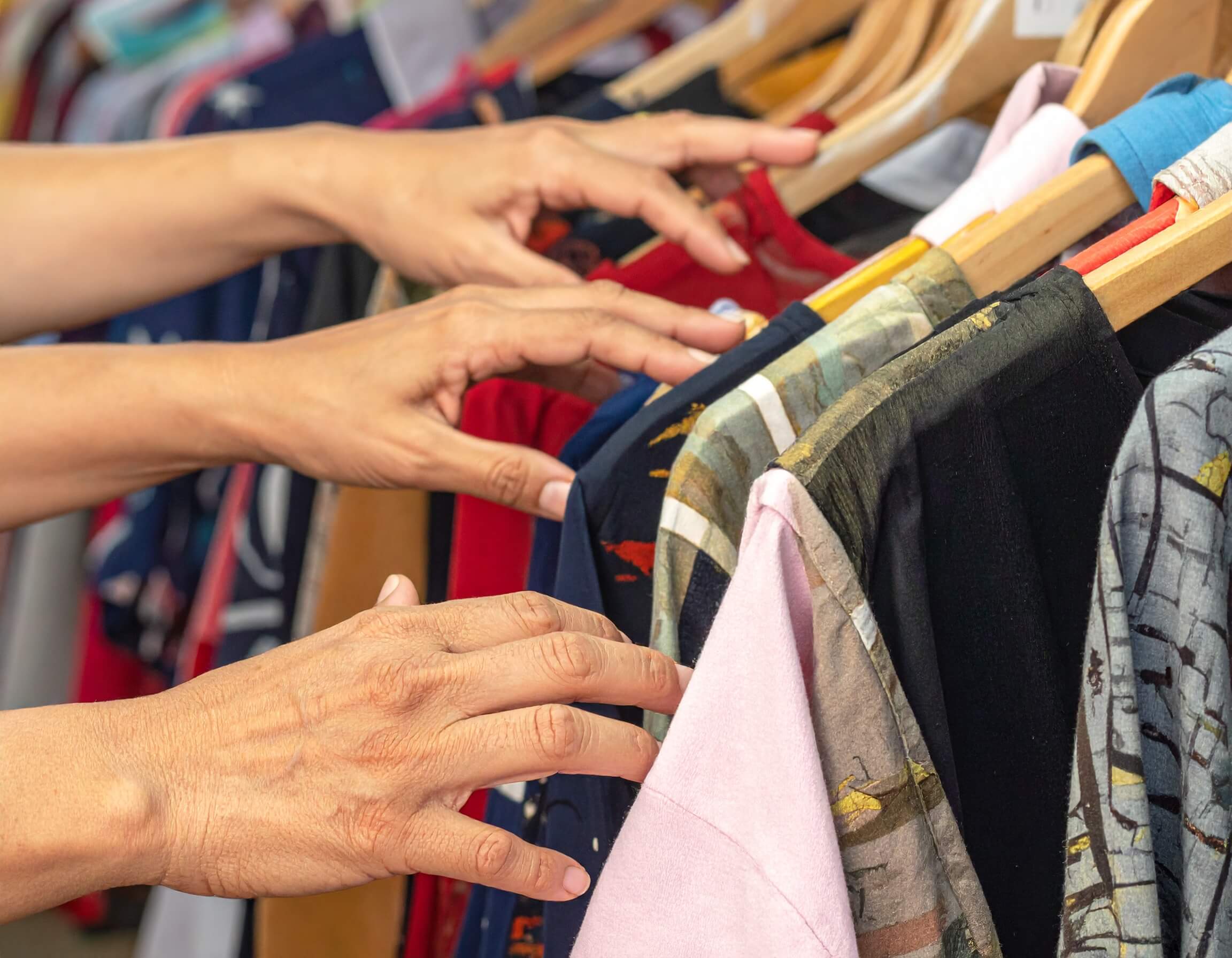 People looking at clothes on a store clothes rack representing retention strategy